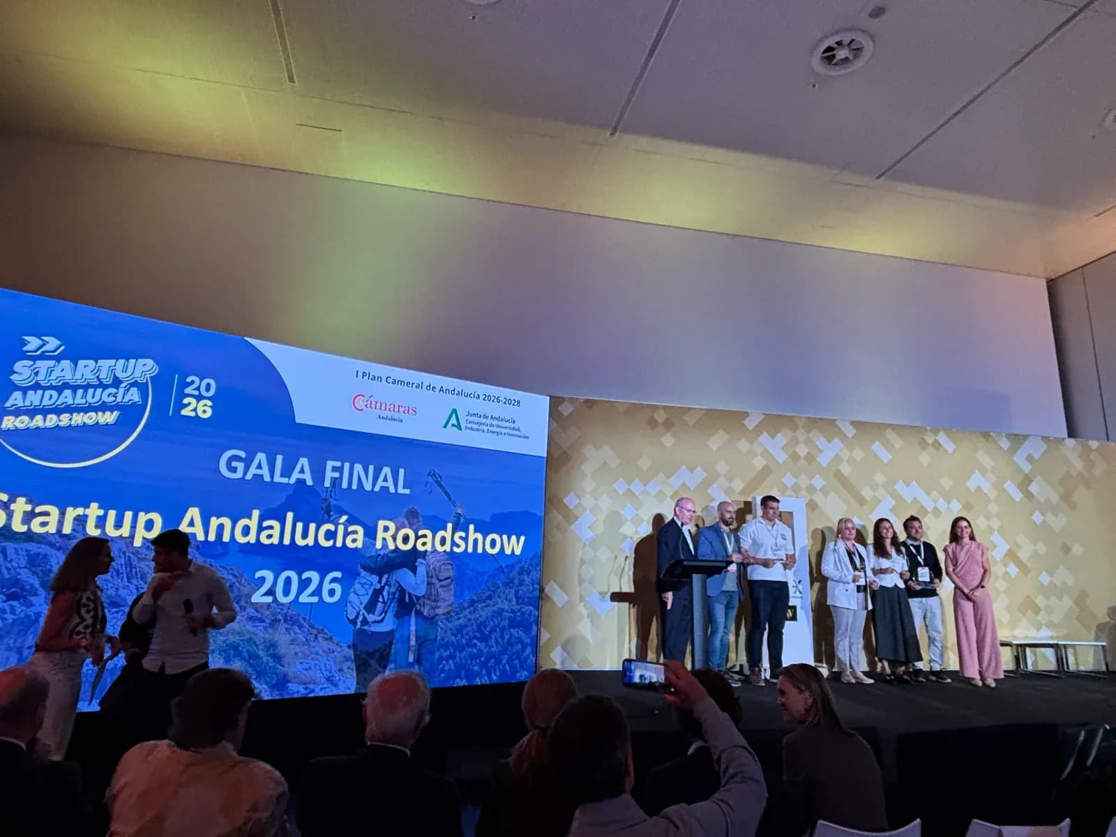 The Startup Andalucía Roadshow 2026 final gala screen next to the winners on stage in Seville